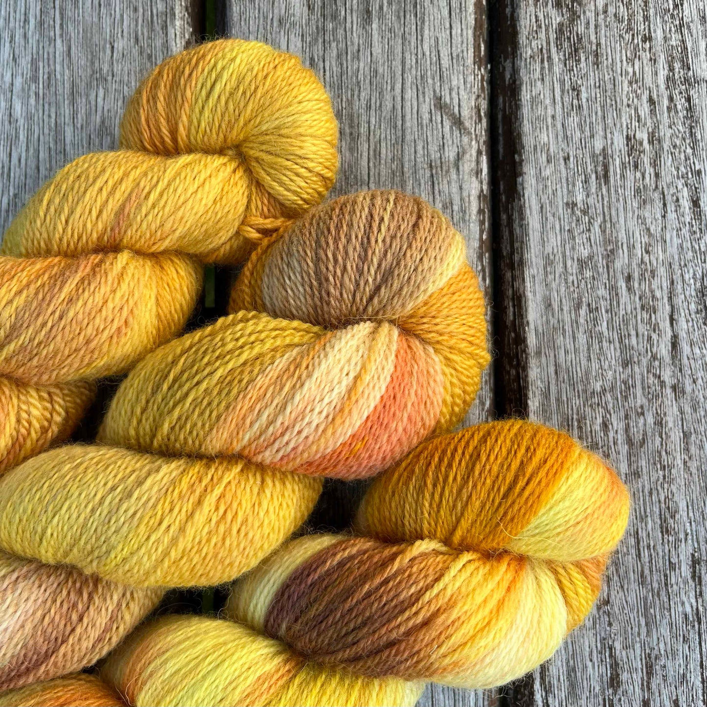 Three skeins of golden yarn peek into the photo from the bottom left.